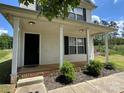 Home with vinyl siding, a covered front porch, and landscaped shrubbery along the front at 1300 Braveheart Ln, Charlotte, NC 28216