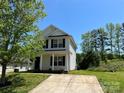 Two-story house with vinyl siding, a front porch, and a concrete driveway at 1300 Braveheart Ln, Charlotte, NC 28216