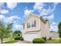 Exterior side view featuring a two-car garage and manicured lawn at 13816 Riding Hill Ave, Charlotte, NC 28213