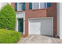Charming brick townhome with a white garage door and attractive green front door at 1707 Kashmir White Ln, Fort Mill, SC 29708