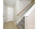 Bright entryway with tile flooring, a staircase featuring white banisters and carpeted steps, and a convenient coat closet at 1905 Mereview Ct # 21, Charlotte, NC 28210