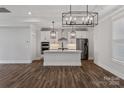 A modern, white kitchen features stainless steel appliances and an island with pendant lighting at 1933 Hendricks St, Rock Hill, SC 29732