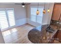 Sun-drenched kitchen area with hardwood floors, island with granite countertop, and modern pendant lighting at 2092 Ayrsley Town Blvd, Charlotte, NC 28273