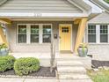 The charming front porch has lovely landscaping and a bright yellow door at 2323 Arden St, Charlotte, NC 28206