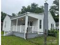 Quaint home showcasing a covered front porch, white siding, and well-maintained landscaping at 247 E Cabarrus Ave, Concord, NC 28025