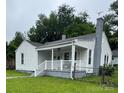 Charming single-story home with a covered front porch, white siding, and a brick chimney at 247 E Cabarrus Ave, Concord, NC 28025