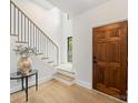 Bright foyer with hardwood floors, wooden front door and staircase with black iron railing at 2608 Croydon Rd, Charlotte, NC 28209