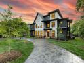 A winding patterned-concrete driveway leads up to the home's black-and-white modern facade and manicured lawn at 2608 Croydon Rd, Charlotte, NC 28209