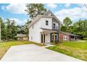 View of a two-story home with modern gray and white exterior and a freshly paved concrete driveway at 424 Airline Ave, Shelby, NC 28150