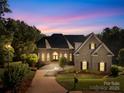 Beautiful brick home at dusk with manicured lawn, and a long driveway, exuding warmth at 458 Inverness Pl, Rock Hill, SC 29730