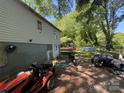 Backyard with various items, including a pool, trampoline, lawnmower, motorcycle, and miscellaneous items strewn around at 506 Sycamore Ave, Gastonia, NC 28052