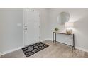 Bright foyer with wood flooring, a modern accent table, a round mirror, and a black and white patterned rug at 5305 Friendly Baptist Church Rd, Indian Trail, NC 28079
