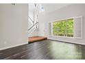 Sun-filled living room boasting dark floors, neutral walls, and large window with views of greenery at 6434 Skyline Dr, Charlotte, NC 28269