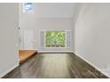Bright living area featuring hardwood floors, a grand window, and neutral paint at 6434 Skyline Dr, Charlotte, NC 28269