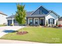 Inviting home with well-kept lawn, charming porch, and Craftsman-style details at 7112 Irongate Dr, Indian Land, SC 29707