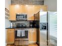 Kitchen with stainless steel appliances, wood cabinets, and tile backsplash at 738 Garden District Dr, Charlotte, NC 28202