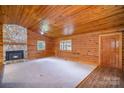 Inviting living room with a stone fireplace, wood-paneled walls and vaulted ceilings at 8464 Robinson Church Rd, Charlotte, NC 28215