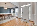 Bright entryway featuring hardwood floors, a stylish rug, and a dining room with navy blue walls at 9217 Tenby Ln, Matthews, NC 28104