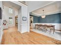 Open-concept home with hardwood floors, a staircase, and a dining room with wainscoting at 9217 Tenby Ln, Matthews, NC 28104