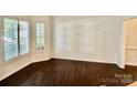 Bright living room features natural light from large windows and dark hardwood floors at 9907 Furlong Trl, Charlotte, NC 28269