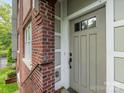 Close-up of a stylish front door with sidelights, complementing the classic brick exterior of the home at 100 N Laurel Ave # 107, Charlotte, NC 28207