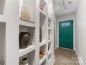 Bright hallway featuring built-in shelves and a vibrant blue door at the end at 100 N Laurel Ave # 107, Charlotte, NC 28207