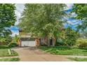 Traditional brick home with an attached two-car garage, lush landscaping, and a spacious driveway at 10418 Goosefoot Nw Ct, Concord, NC 28027