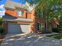 Spacious home featuring a large driveway, attached garage, and a classic brick facade at 10418 Goosefoot Nw Ct, Concord, NC 28027