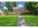 Charming two-story brick home with a lush front lawn and a welcoming walkway to the entrance at 1101 Pee Dee Ave, Albemarle, NC 28001