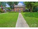 Beautiful two-story brick home with a sprawling front lawn and inviting walkway at 1101 Pee Dee Ave, Albemarle, NC 28001