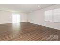 Spacious living room featuring wood-look flooring and ample natural light from sliding glass doors at 11019 Daisy Ct, Charlotte, NC 28262