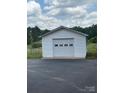 Detached white garage with roll up door situated on a large lot at 1120 Mcintyre Rd, Wingate, NC 28174