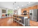 Inviting kitchen with a breakfast bar, stainless steel refrigerator, and hardwood floors at 119 Steinbeck Way # E, Mooresville, NC 28117