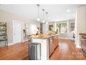 Kitchen featuring stainless steel appliances, a breakfast bar, and hardwood floors at 119 Steinbeck Way # E, Mooresville, NC 28117