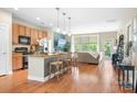 Bright, open-concept living space with hardwood floors, kitchen island, and natural light at 119 Steinbeck Way # E, Mooresville, NC 28117