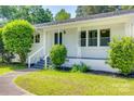 Close up of the home's charming white brick facade, well-kept lawn and decorative porch at 1423 Ebinport Rd, Rock Hill, SC 29732