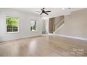 Open-concept living room featuring shiplap walls, wood floors, and staircase at 1513 Landis Ave, Charlotte, NC 28205