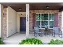 Inviting front porch featuring chairs, stone and vinyl siding, a decorative door, and manicured shrubbery at 159 Saye Pl, Mooresville, NC 28115