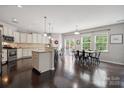 Bright and open kitchen featuring white cabinets, granite countertops, stainless steel appliances, and a dining area at 16114 Foreleigh Rd, Huntersville, NC 28078