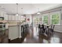 Bright and open kitchen featuring white cabinets, granite countertops, stainless steel appliances, and a dining area at 16114 Foreleigh Rd, Huntersville, NC 28078