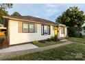 A welcoming single-story home boasting neutral siding, a bright yellow front door, and a well-maintained lawn at 2012 Double Oaks Rd, Charlotte, NC 28206