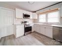 Modern kitchen featuring sleek stainless steel appliances, white cabinets, a window and light colored flooring at 2123 W Sixth Ave, Gastonia, NC 28052
