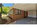Attached carport, brick facade, black framed windows and flower planters at 2203 Arney St, Lincolnton, NC 28092