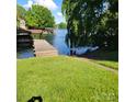 A grassy lawn leads to a private dock with a covered boat slip, offering easy lake access at 221 Stillwater Rd, Troutman, NC 28166