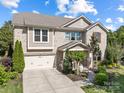 Attractive two-story brick home with a well-manicured lawn, landscaping, and an attached two-car garage at 300 Hidden Cove Ln, Matthews, NC 28104