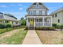 Beautiful two-story home with a welcoming front porch, complemented by a bright yellow door at 423 State St, Charlotte, NC 28208