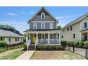 Inviting two-story home boasting a classic front porch and well-maintained landscaping at 423 State St, Charlotte, NC 28208