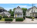 Charming two-story home with a welcoming front porch, yellow door, and beautifully landscaped yard at 423 State St, Charlotte, NC 28208