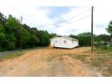 A well-maintained, light yellow home with a wood deck, situated on a partially landscaped lot near a quiet street at 462 Berry Hill Dr, Norwood, NC 28128