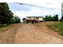Charming home featuring a metal roof, deck, and garage nestled on a partially landscaped lot at 462 Berry Hill Dr, Norwood, NC 28128